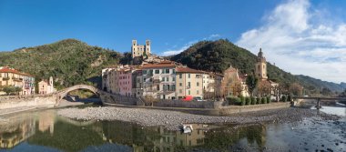 Dolceacqua, Italy. Panorama of the town with romanesque bridge (Ponte Vecchio), over the Nervia river and ruins of medieval castle clipart
