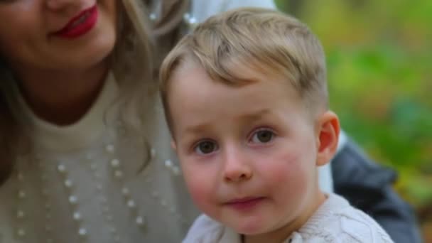 Filho com a mãe em um parque da cidade no outono . — Vídeo de Stock