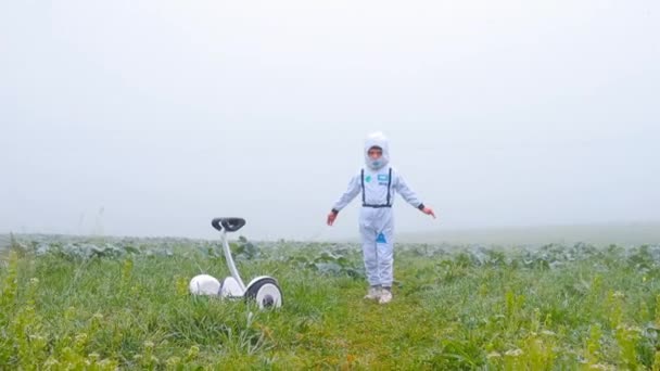 Bir astronot beyaz bir tarlada kollarını açmış esir tutuluyor. — Stok video