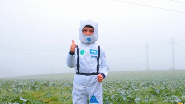 A boy in a white astronaut costume shows a like sign. — Stock Video