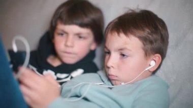 İki çocuk evde otururken akıllı telefon kullanıyor..