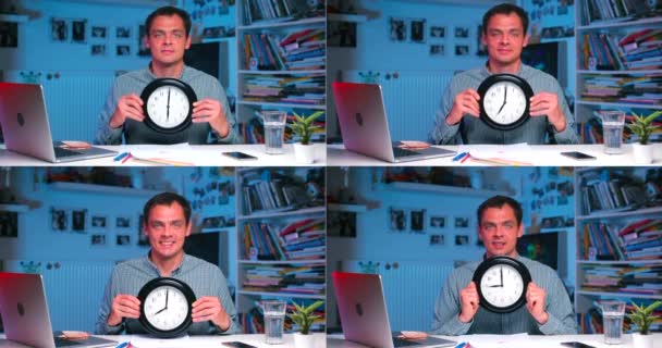 Bir adam ofis masasında elinde bir saat tutuyor.. — Stok video