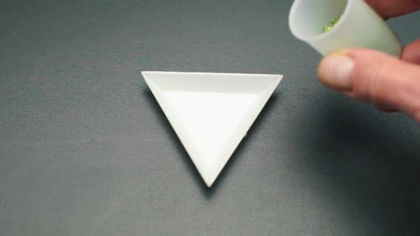 Наливаємо зелений бісер в трикутну тарілку в ювелірну майстерню . — стокове відео