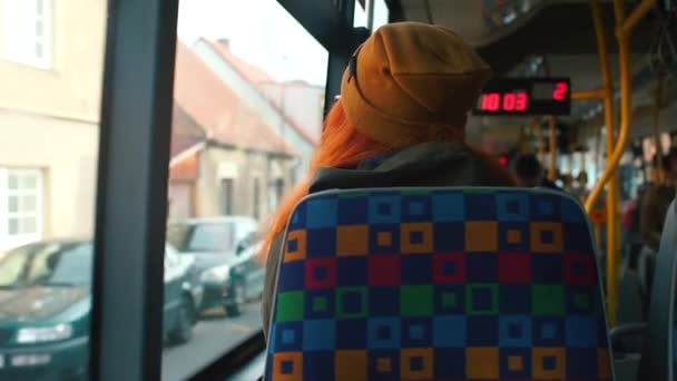 The passenger of a public transport bus looks out the window. — Stockvideo