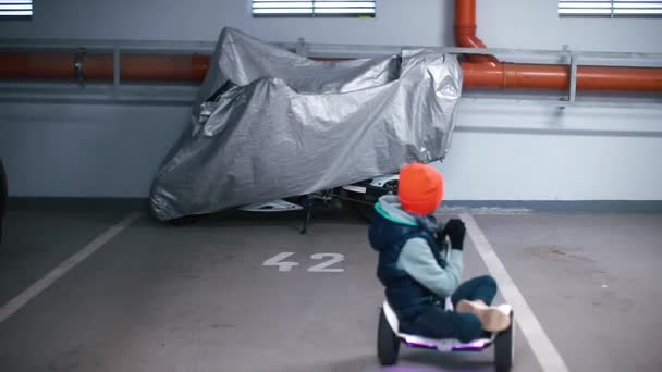 Een jongen op een gyroscooter in een parkeerplaats 42 — Stockvideo