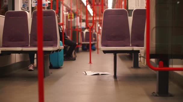 Noviny leží na podlaze vlaku metra.. — Stock video