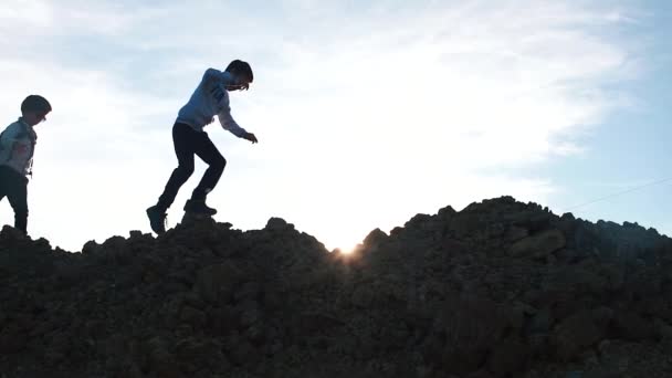 Twee jongens, broers, wandelen langs de berg op een reis. — Stockvideo