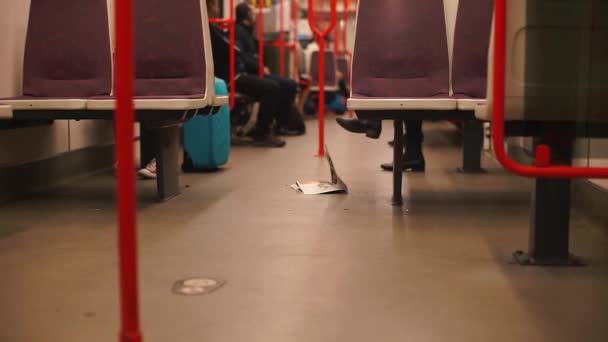 Il giornale si trova sul pavimento del treno della metropolitana . — Video Stock