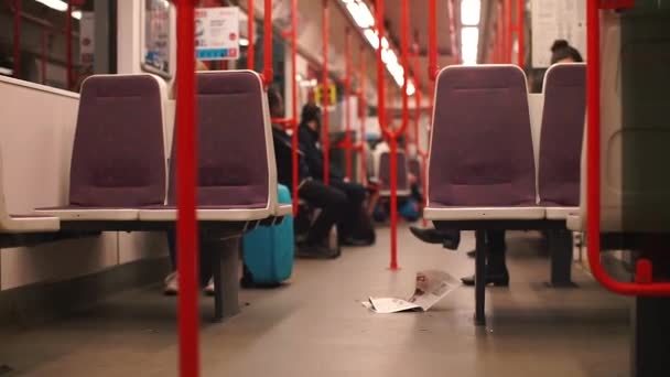 U-Bahn-Zug. Auf dem Fußboden liegt eine Zeitung. Mehrere freie Plätze. — Stockvideo