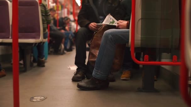 Een man die een boek leest in een treinwagon met het openbaar vervoer. — Stockvideo