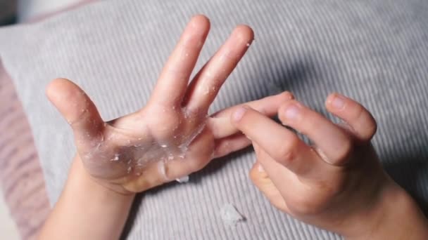 El niño rasga pegamento de las palmas de sus manos . — Vídeos de Stock