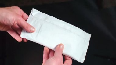 Bir adam zarfı açmaya hazırlanıyor..