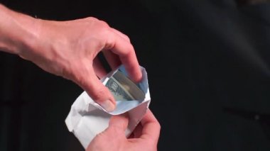 Bir polis yolsuzluğa bulaşmış memurları tutuklarken bir zarfta para gösteriyor..