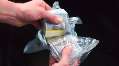 Bir uyuşturucu satıcısı elinde kirli para tutuyor..