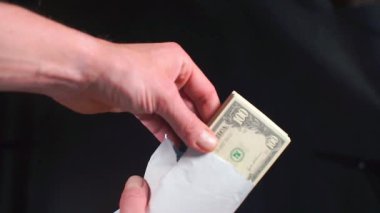 Bankacı meşe ağacında bir tomar 100 dolarlık banknot tutuyor.