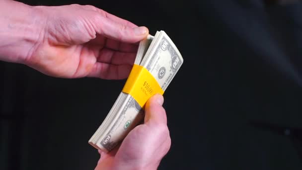Un hombre de negocios tiene un paquete de billetes de cien dólares. . — Vídeos de Stock