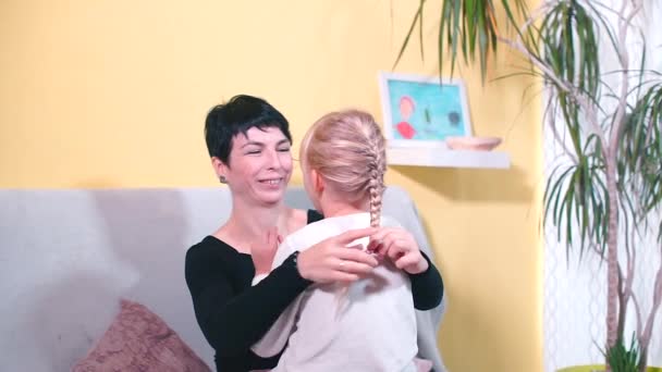 Maman lesbia avec une planche s'assoit sur le canapé à la maison . — Video