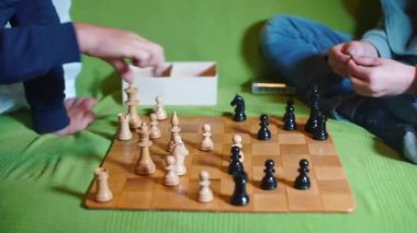 İki kişi satranç oynar. Satranç taşları ellerini oynatıyor..