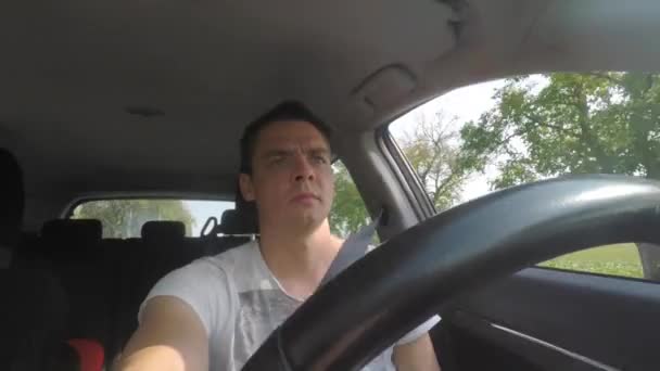 Un homme conduit une voiture. Il met des lunettes sur ses yeux au moment du mouvement . — Video