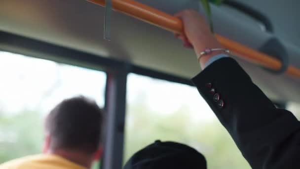 Dłoń pracownika biurowego trzyma się poręczy autobusu. — Wideo stockowe