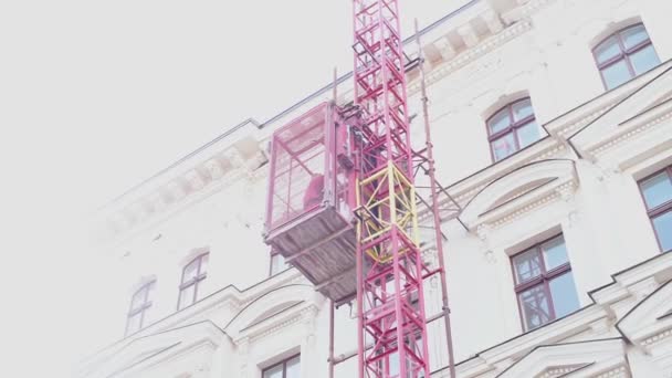 Внешний лифт здания поднимается на верхнюю часть здания — стоковое видео