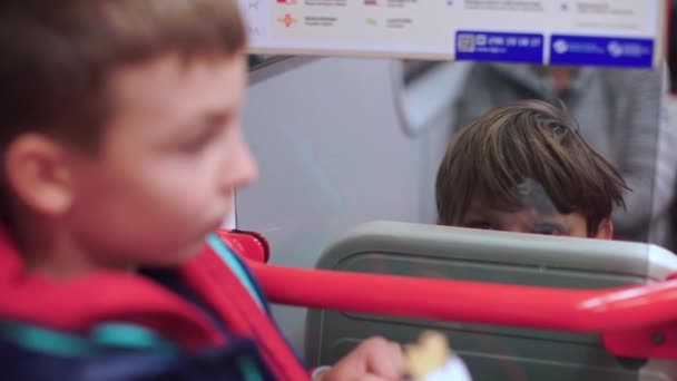 Dos hermanos en el tren del metro se miran, haciendo muecas. . — Vídeo de stock