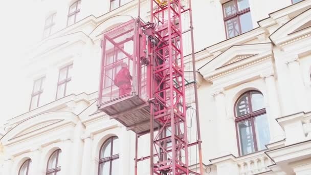 Um elevador externo sobe com a pessoa para o topo . — Vídeo de Stock