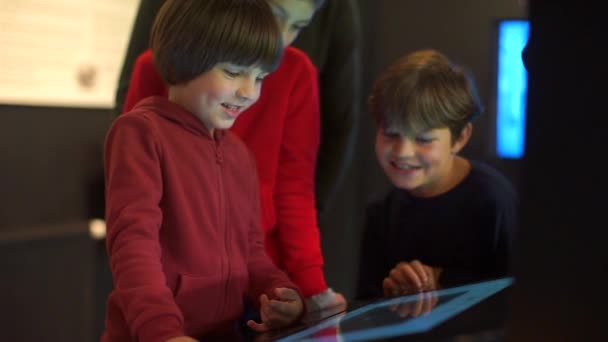 Tres hermanos de pie cerca del teclado táctil, monitor — Vídeo de stock