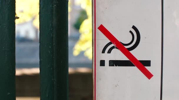 Sign no smoking. A sign hangs on the fence of a city park — Stock Video