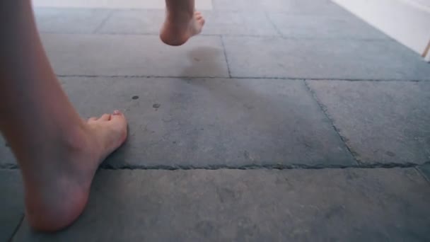 Natte, blote voeten stappen op de stenen vloer, sporen achterlaten — Stockvideo