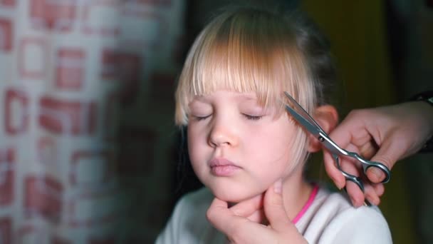 Gros plan d'une fille qui se coupe les cheveux sur la tête . — Video