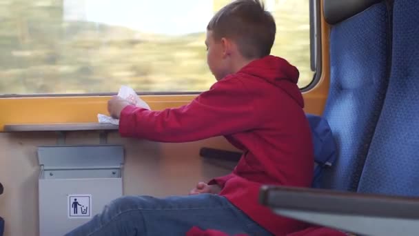 Egy tinédzser vonattal utazik. Élelmiszer-fogyasztás. — Stock videók
