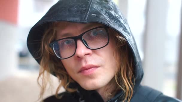 Portrait d'un gars dans une capuche avec des lunettes humides — Video