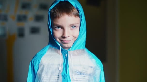 Портрет веселого школьника в синем плаще — стоковое видео