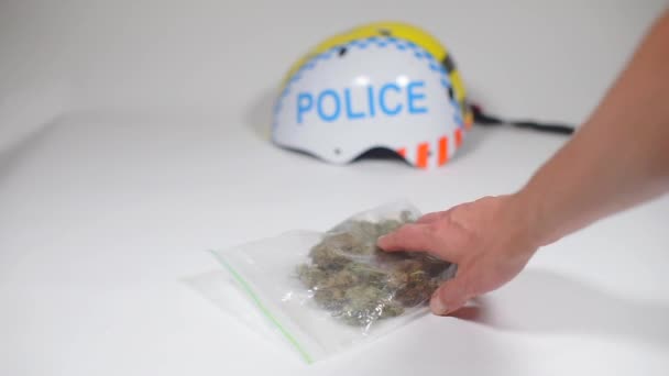 Polisen kastar en cannabispåse på bordet. — Stockvideo