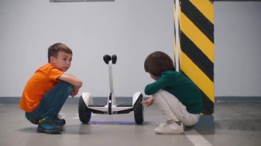 İki kardeş otoparkta bir jiroskopun teknik verilerini tartışıyor.