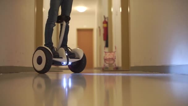 Um homem de pé em um hoverboard faz U-voltas no local — Vídeo de Stock