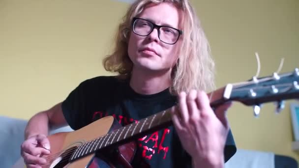 Учитель музыки в очках играет на акустической гитаре — стоковое видео