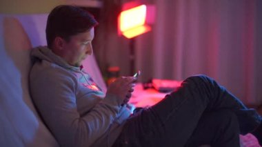 Partideki adam taksi çağırmak için akıllı telefon kullanıyor.