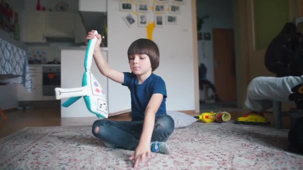 Uma criança está brincando com um brinquedo macio um robô na sala — Vídeo de Stock