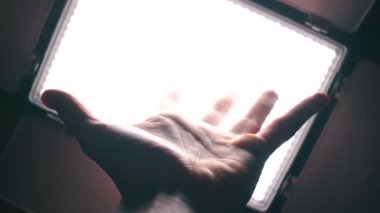 Parlak ışık arka planında ellerin yakın plan görüntüsü.