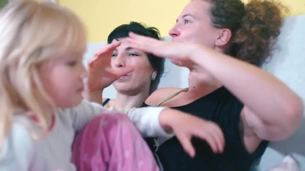 Les partenaires LGBT avec leur fille sont assis sur le canapé à la maison . — Video