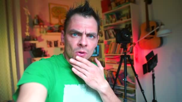 El video bloguero sorprendido sostiene una cámara en sus manos . — Vídeos de Stock