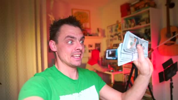 Der emotionale Typ, den der Blogger in seinen Händen hält, viel Geld — Stockvideo