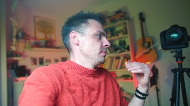 빨간 옷을 입은 한 블로거 가손에 카메라를 들고 자신의 사진을 찍는다 — 비디오
