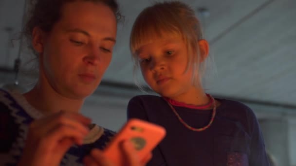 妈妈和女儿在看智能手机的屏幕. — 图库视频影像