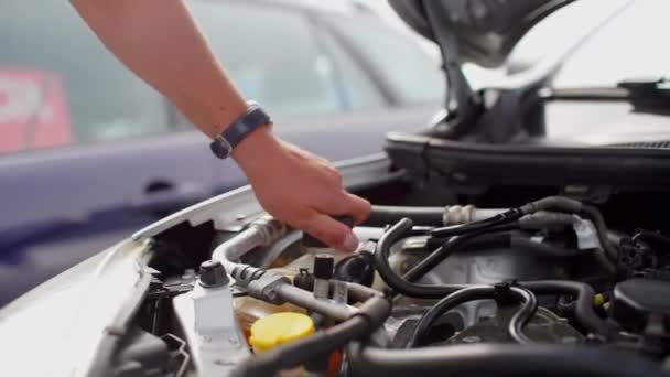 Autoliefhebber schroeft het deksel van het vloeistofreservoir van de wasmachine los — Stockvideo