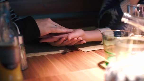 Leszbikus megérinti a partnere kezét egy asztalnál egy étteremben. — Stock videók