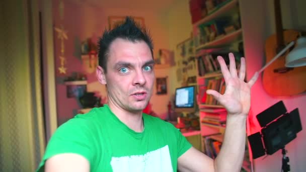 Емоційний блогер в зеленому одязі розповідає передплатникам п'ять пунктів . — стокове відео