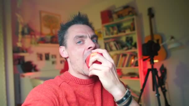 Emocionální blogger ukousne jablko. Haughty mluví o tématu. — Stock video